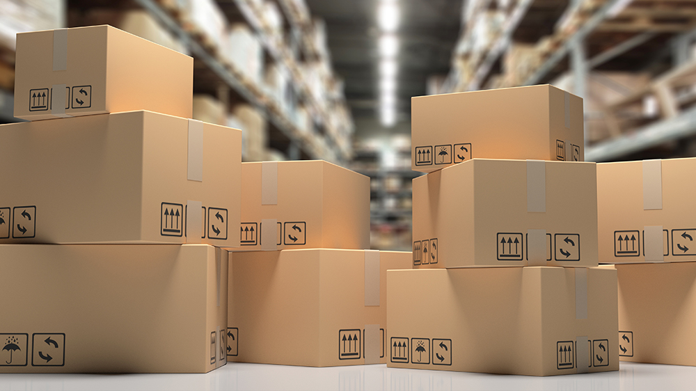 A number of cardboard boxes sit in a warehouse, ready to be shipped to an Amazon Fulfillment Centre.