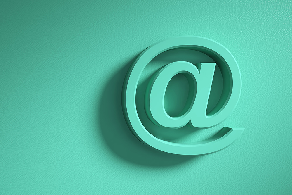 An asperand symbol sits in a turquoise green and slightly textured background. The symbol signifies email communication.