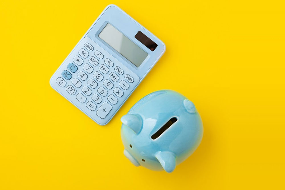 A free Amazon profit calculator for Amazon arbitrage next to a piggy bank.