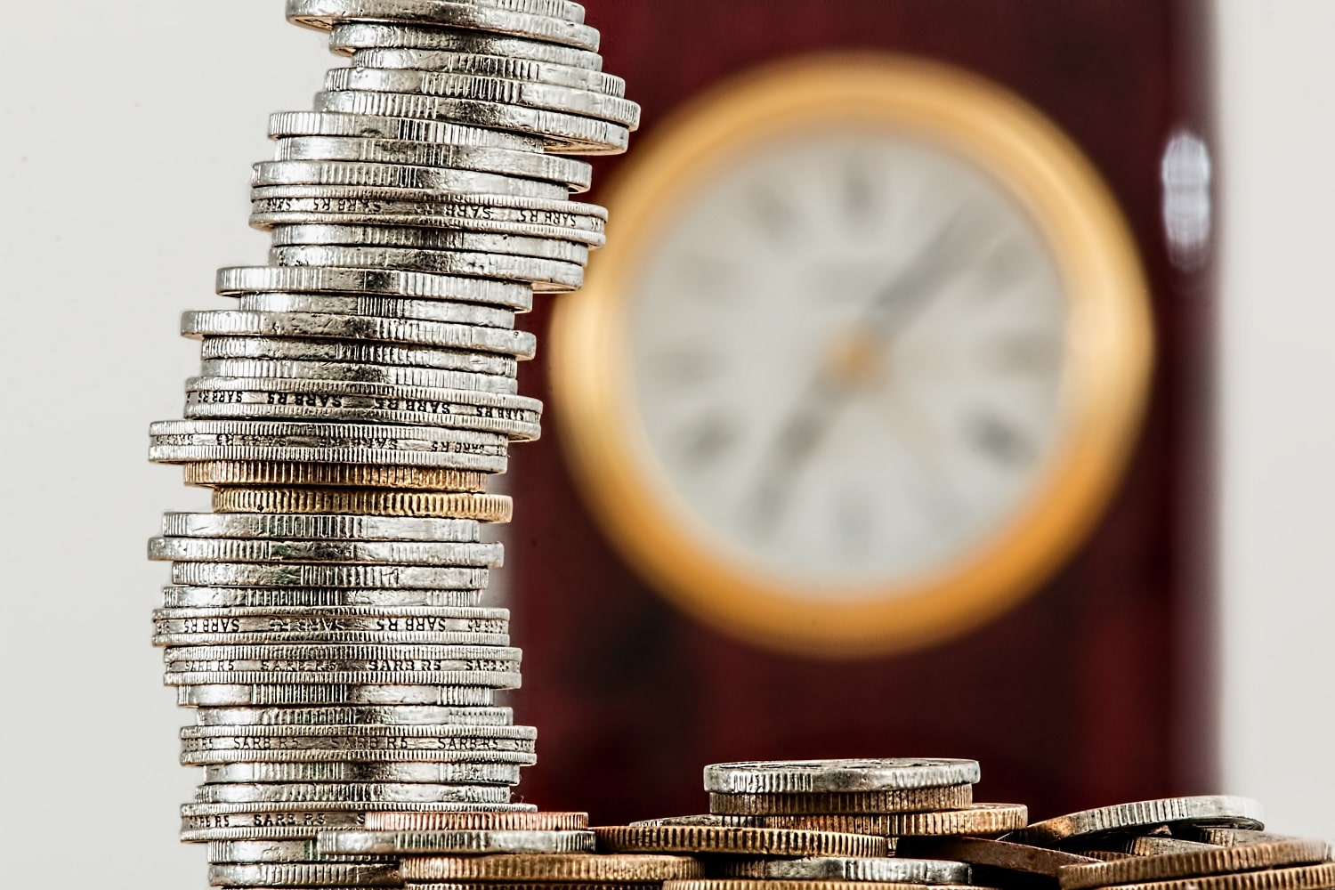 A pile of coins with a clock in the background, representing time savings made by sellers when they start using an Amazon prep centre.