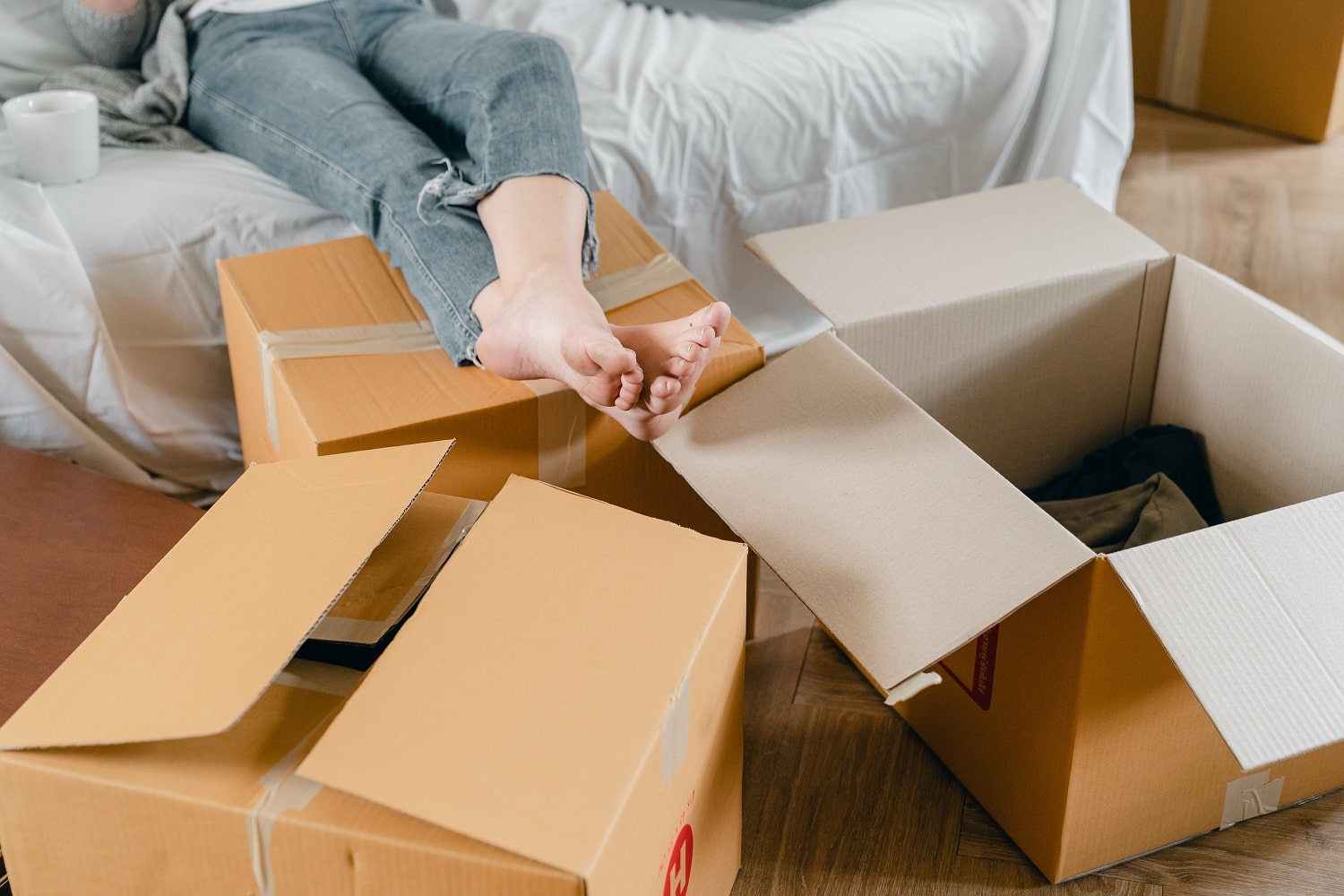 An Amazon seller surrounded by boxes at home with feet up on the sofa.