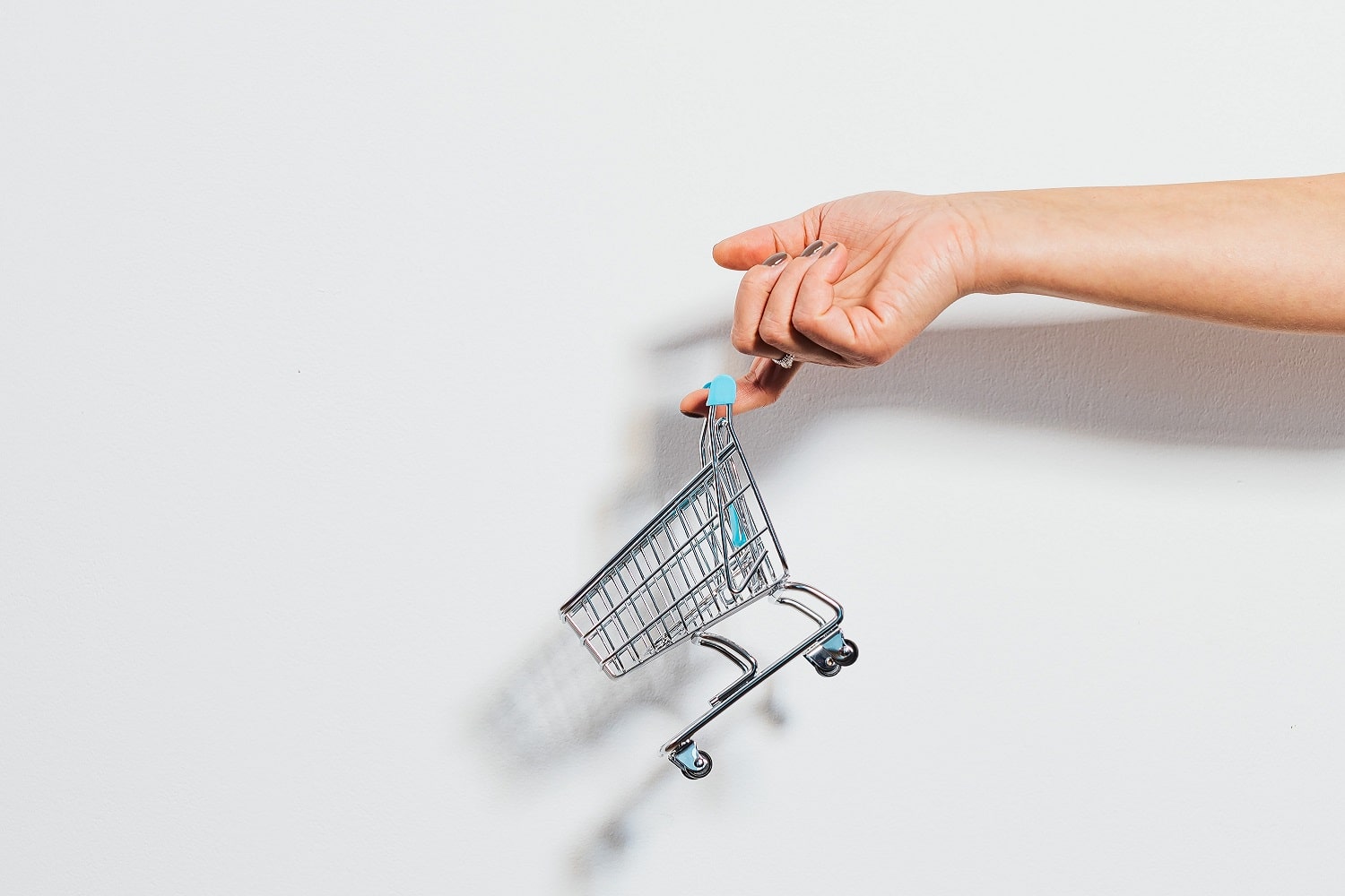 An Amazon seller holding a miniature shopping cart.
